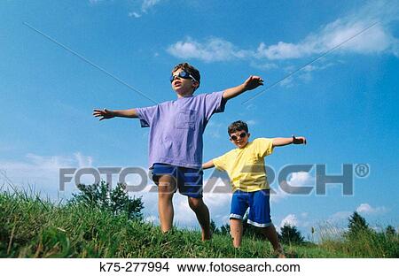 Picture - young brothers pretending to fly. Fotosearch
