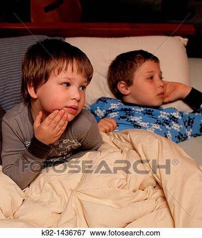Young brothers watching tv together View Large Photo Image Stock Photo - Young brothers watching tv together. Fotosearch