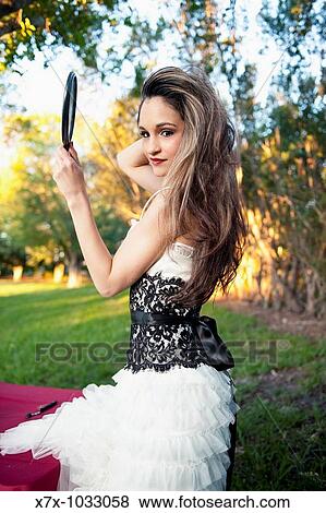 Young brunette Hispanic woman stares in the mirror at herself, even while in the park View Large Photo Image Stock Photo - Young brunette Hispanic woman stares in the mirror at herself, even while in the park. Fotosearch