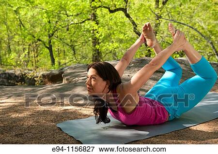 Young brunette woman doing yoga poses in a forest setting in the springtime. View Large Photo Image Stock Photo - Young brunette woman doing yoga poses in a forest setting in the springtime.. Fotosearch