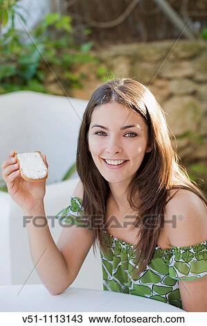 Young brunette woman enjoying breakfast outdoors View Large Photo Image Stock Image - Young brunette woman enjoying breakfast outdoors. Fotosearch