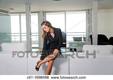 Young business woman arriving home and taking out her heels View Large Photo Image Stock Photo - Young business woman arriving home and taking out her heels. Fotosearch