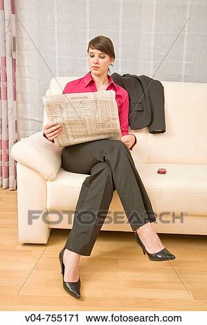 Stock Image - Young business woman reading a newspaper. Fotosearch