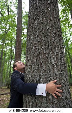 Young businessman in forest hugging tree View Large Photo Image Stock Photo - Young businessman in forest hugging tree. Fotosearch