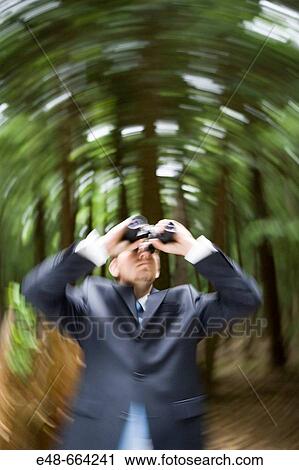 Young businessman in forest looking through binoculars View Large Photo Image Stock Image - Young businessman in forest looking through binoculars. Fotosearch