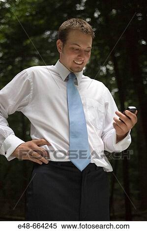 Young businessman in forest with cellular phone View Large Photo Image Stock Photography - Young businessman in forest with cellular phone. Fotosearch