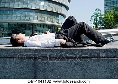Young businessman relaxes in More London Place development, near City Hall, London, UK View Large Photo Image Stock Image - Young businessman relaxes in More London Place development, near City Hall, London, UK. Fotosearch