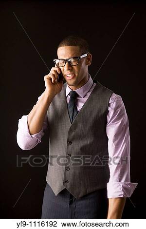 Young businessman talking on cell phone. View Large Photo Image Stock Image - Young businessman talking on cell phone.. Fotosearch