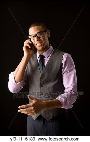 Stock Photo - Young businessman talking on cell phone.. Fotosearch