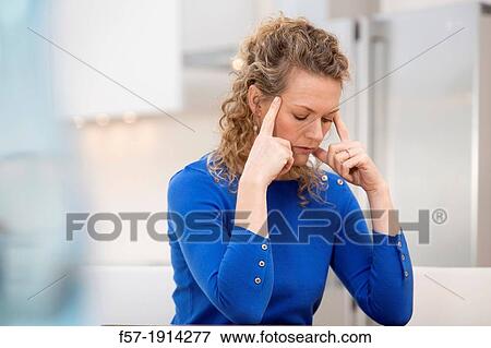 Young businesswoman at home with a headache View Large Photo Image Stock Photo - Young businesswoman at home with a headache. Fotosearch