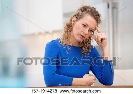 Young businesswoman at home with a headache View Large Photo Image Stock Photo - Young businesswoman at home with a headache. Fotosearch