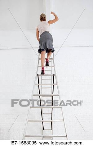 Young businesswoman climbing a ladder View Large Photo Image Stock Photography - Young businesswoman climbing a ladder. Fotosearch