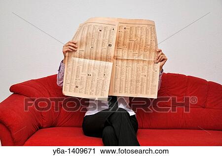 Young businesswoman sitting on sofa reading financial newspaper View Large Photo Image Stock Image - Young businesswoman sitting on sofa reading financial newspaper. Fotosearch