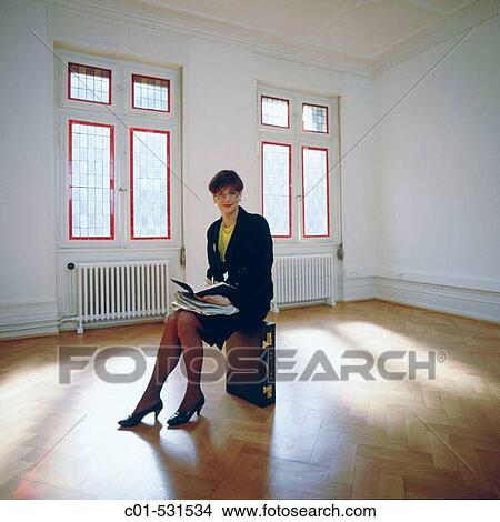 Young businesswoman with black dress sitting in empty room View Large Photo Image Picture - Young businesswoman with black dress sitting in empty room. Fotosearch
