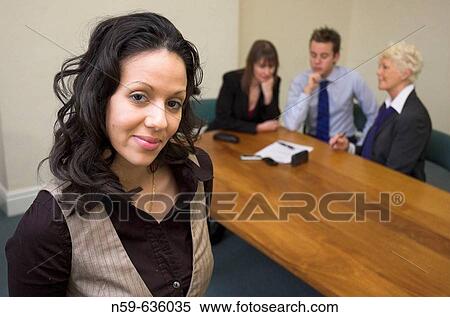 Stock Photography - Young businesswoman with business team in background.. Fotosearch