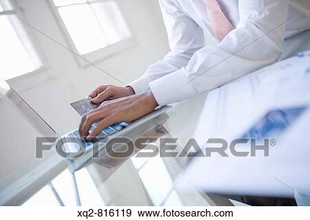 Young bussinessman shopping online View Large Photo Image Stock Photo - Young bussinessman shopping online. Fotosearch