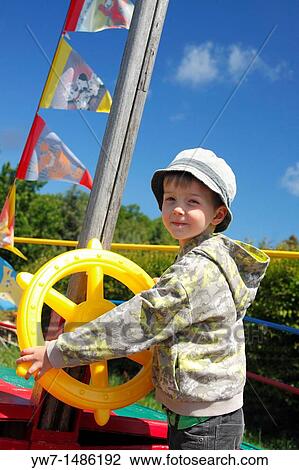 Young captain behind the toy steer wheel View Large Photo Image Stock Image - Young captain behind the toy steer wheel. Fotosearch