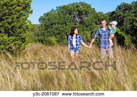 Young caucasian couple, man is 25, woman is 22 years old, with toddler boy, walking through tall grass in natural environment. View Large Photo Image Stock Photo - Young caucasian couple, man is 25, woman is 22 years old, with toddler boy, walking through tall grass in natural environment.. Fotosearch
