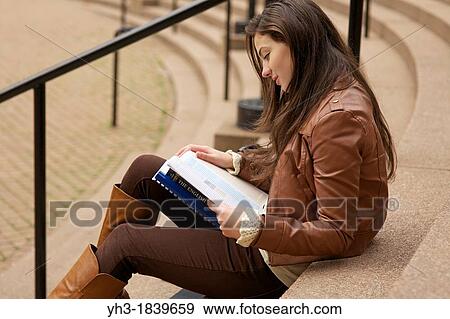 Young caucasian girl reading textbook at a university library View Large Photo Image Stock Photo - Young caucasian girl reading textbook at a university library. Fotosearch