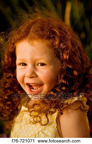 Stock Image - Young caucasian girl with cury red hair, aged 3yrs 7 months old smiling. Fotosearch