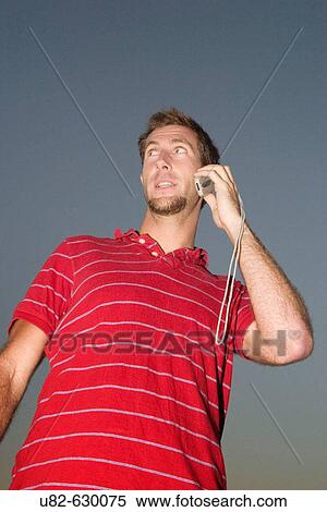 Young Caucasian man on a mobile cell phone during dusk, San Francisco, California, USA. View Large Photo Image Stock Photography - Young Caucasian man on a mobile cell phone during dusk, San Francisco, California, USA.. Fotosearch
