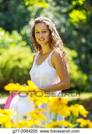 Stock Photography - Young caucasian woman 33 years outdoor among flowers.. Fotosearch