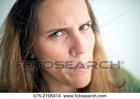 Picture - Young Caucasian woman with blond hair and green eyes with anger expression.. Fotosearch