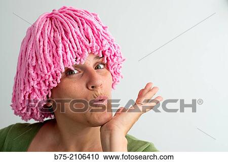 Stock Image - Young Caucasian woman with pink wig with cheerful expression.. Fotosearch