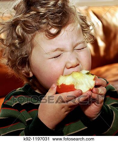 Young child eating an apple. View Large Photo Image Stock Image - Young child eating an apple.. Fotosearch