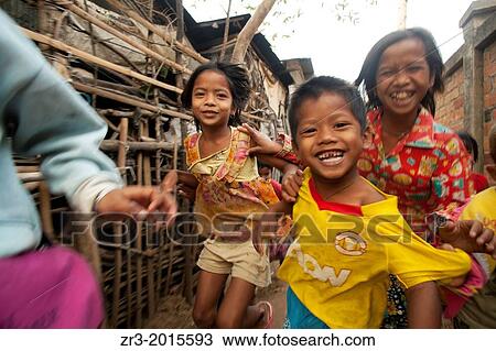 Stock Image - Young children run through a small village near Battambang, Cambodia.. Fotosearch