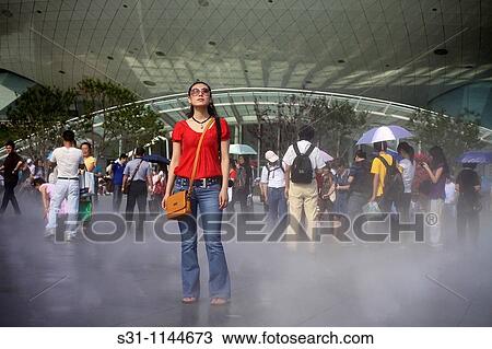 Stock Image - young chinese woman visiting the 2010 shanghai expo. Fotosearch