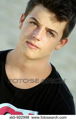 Young confident looking man isolated on sand background View Large Photo Image Stock Photo - Young confident looking man isolated on sand background. Fotosearch