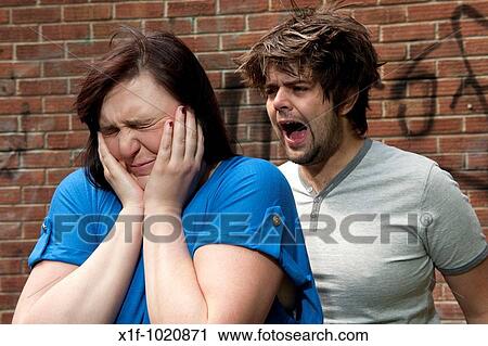 Young couple arguing, shouting, relationship breakdown, woman holding her hands over her ears View Large Photo Image Stock Image - Young couple arguing, shouting, relationship breakdown, woman holding her hands over her ears. Fotosearch