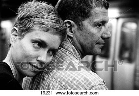 Stock Image - Young couple at train station. Fotosearch