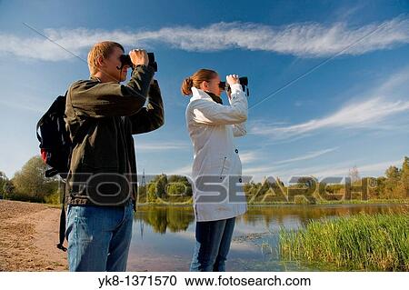 Young couple birdwatching with binoculars View Large Photo Image Stock Image - Young couple birdwatching with binoculars. Fotosearch