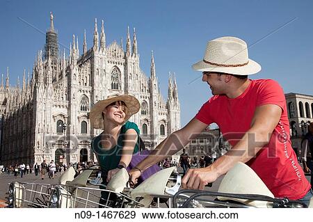 Young couple cycling in milan View Large Photo Image Stock Photo - Young couple cycling in milan. Fotosearch