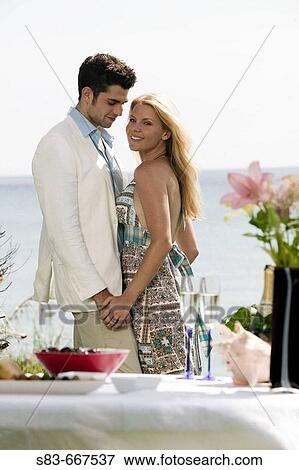 Young couple dining at the beach View Large Photo Image Stock Photo - Young couple dining at the beach. Fotosearch
