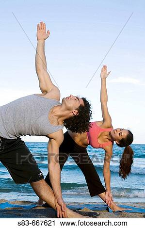 Young couple doing voga on the beach View Large Photo Image Stock Image - Young couple doing voga on the beach. Fotosearch
