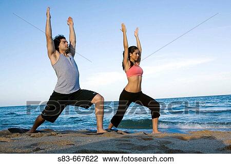 Young couple doing voga on the beach View Large Photo Image Stock Image - Young couple doing voga on the beach. Fotosearch