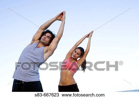 Young couple doing voga on the beach View Large Photo Image Stock Image - Young couple doing voga on the beach. Fotosearch