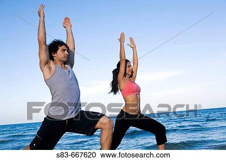 Young couple doing yoga on the beach View Large Photo Image Stock Image - Young couple doing yoga on the beach. Fotosearch