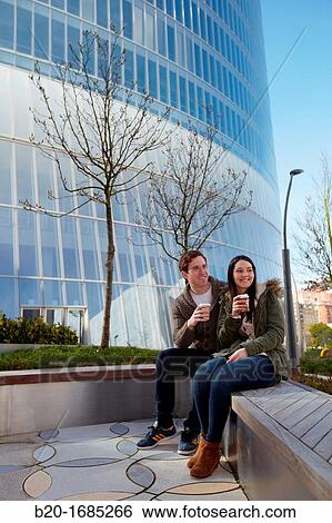 Young couple drinking coffee in the city, Iberdrola Tower, Abandoibarra, Bilbao, Bizkaia, Basque Country, Spain View Large Photo Image Stock Photograph - Young couple drinking coffee in the city, Iberdrola Tower, Abandoibarra, Bilbao, Bizkaia, Basque Country, Spain. Fotosearch