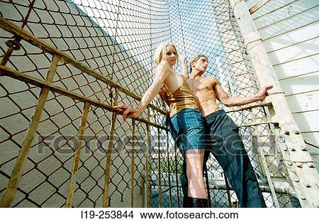 Young couple embracing against fence View Large Photo Image Picture - Young couple embracing against fence. Fotosearch