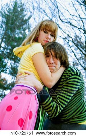 Stock Image - Young couple embracing outside. Fotosearch