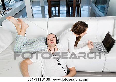 Young couple enjoying leisure at home View Large Photo Image Stock Photograph - Young couple enjoying leisure at home. Fotosearch