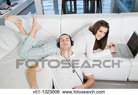 Young couple enjoying leisure at home View Large Photo Image Stock Photograph - Young couple enjoying leisure at home. Fotosearch
