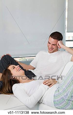 Stock Photo - Young couple enjoying leisure time at home. Fotosearch