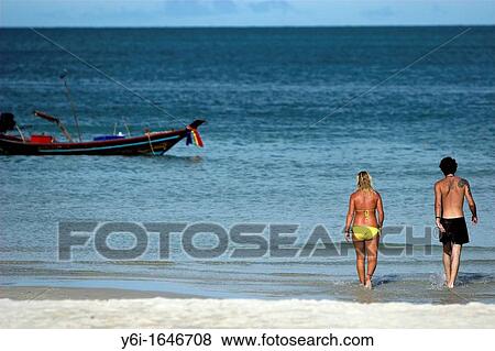Stock Photo - Young couple go for swim Ko Pha Ngan island Thailand. Fotosearch