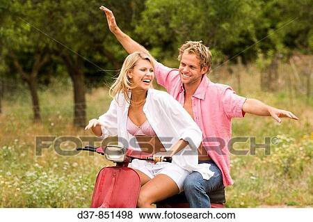 Young couple having fun on a scooter View Large Photo Image Stock Photo - Young couple having fun on a scooter. Fotosearch
