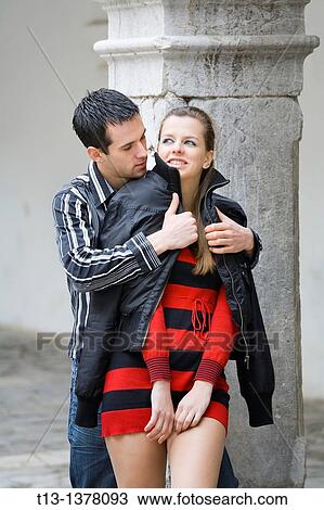 Young couple he is putting a jacket on her View Large Photo Image Stock Image - Young couple he is putting a jacket on her. Fotosearch